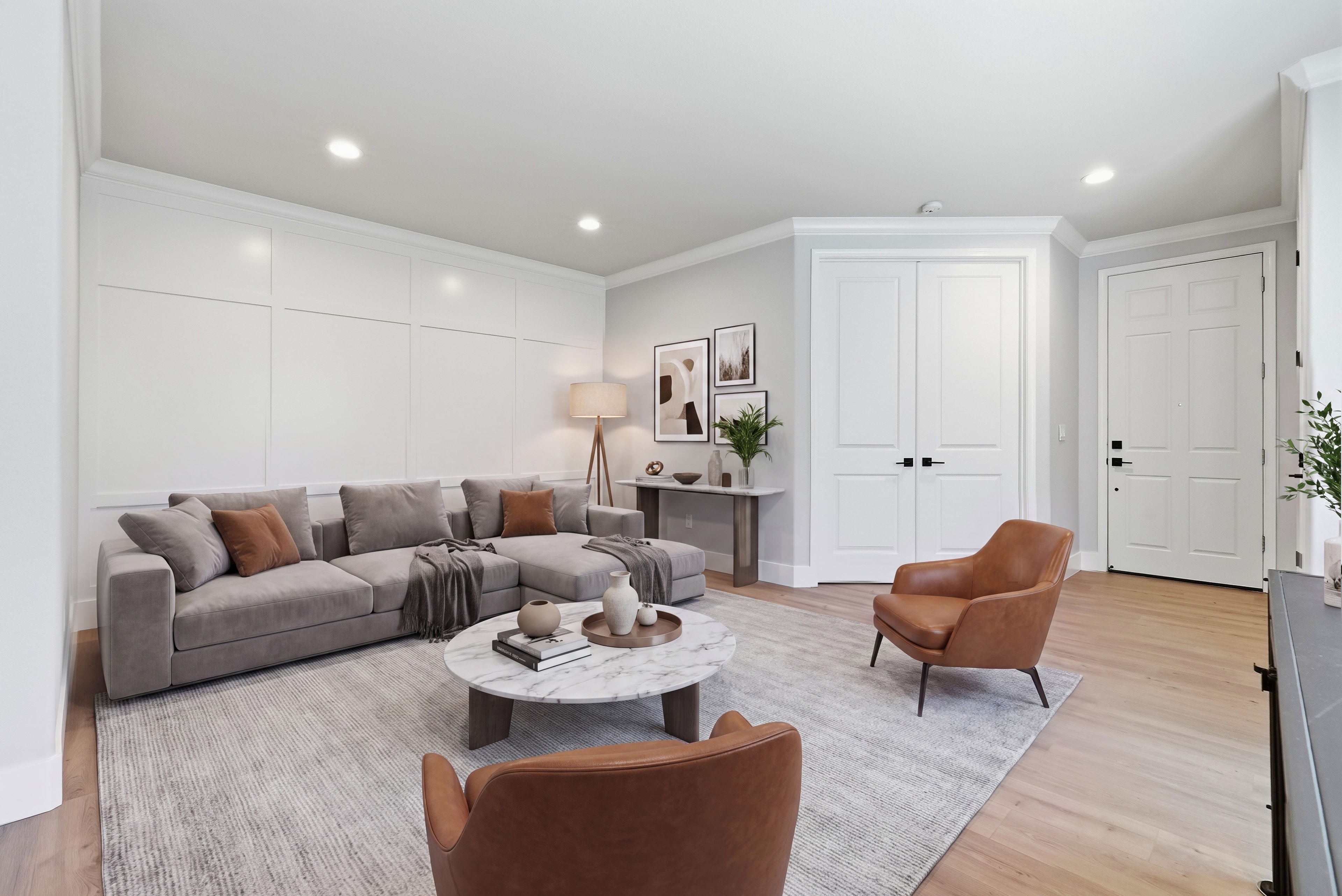 Spacious living room with gray sectional, leather chairs and marble coffee table
